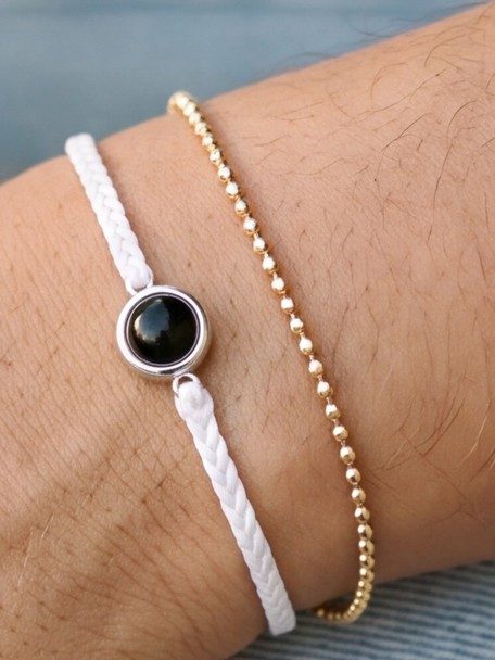 White cord Circle Photo Bracelet worn with a gold bead chain bracelet