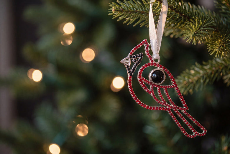 Red crystal cardinal photo ornament hanging on a lit Christmas tree